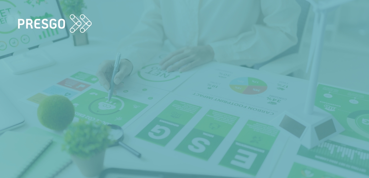 Persona analizando informes de huella de carbono e indicadores ESG sobre una mesa de trabajo, con el logo de Presgo superpuesto.